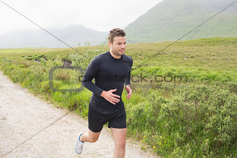 Fit man jogging on a trail