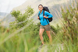 Female hiker with backpack walking and smiling