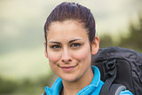 Female hiker with backpack smiling at camera