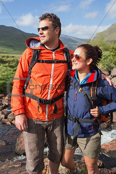 Couple wearing rain jackets and sunglasses admiring the view