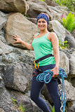 Attractive female rock climber smiling at camera