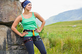 Pretty female rock climber leaning on rock face
