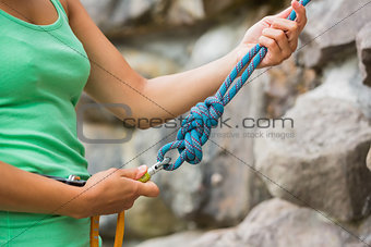 Female rock climber adjusting harness