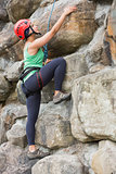 Pretty girl climbing rock face