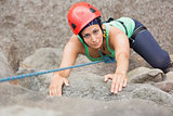 Determined girl climbing rock face