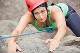 Focused girl climbing rock face