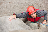 Determined man climbing rock face