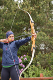 Focused brunette practicing archery