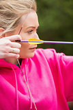 Focused blonde practicing archery