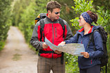 Fit couple going on a hike together looking at map