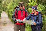 Happy couple going on a hike together looking at map