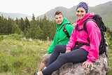 Couple sitting on a rock resting during hike