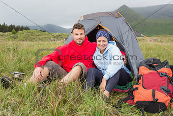 Couple on camping trip smiling at camera