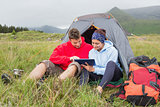 Couple on camping trip using a digital tablet