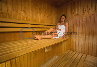 Calm brunette relaxing in a sauna