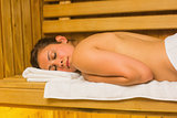Calm brunette lying down in a sauna