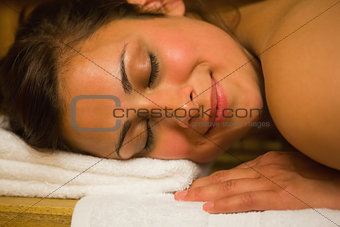 Happy brunette lying in a sauna