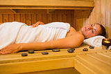 Peaceful brunette woman lying in a sauna