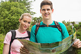 Athletic couple holding map on a hike