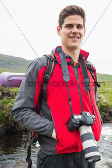 Happy man on a hike with a camera around his neck