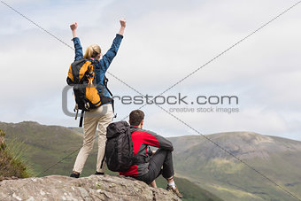 Excited couple reaching the top of their hike