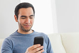 Smiling casual man text messaging