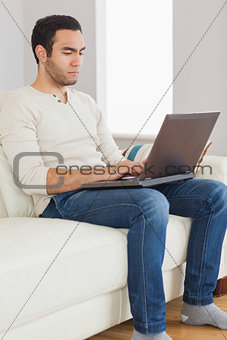 Focused handsome man using his tablet computer