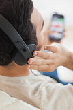 Close up on young man listening to music on his smartphone