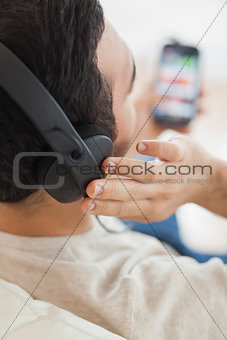 Close up on young man listening to music on his smartphone