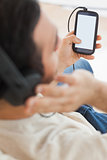 Close up on young man using his smartphone to listen to music