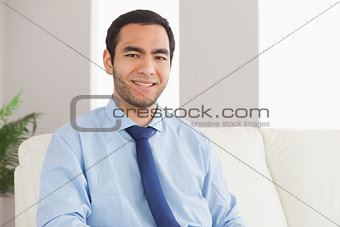Cheerful businessman sitting on cosy sofa