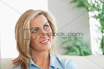 Thinking woman sitting on a sofa