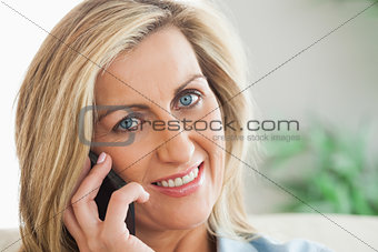 Smiling woman calling someome with her mobile phone