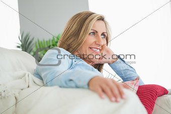 Happy woman lying on a sofa