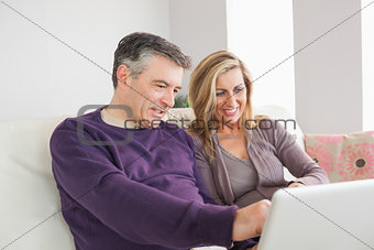 Happy couple watching their laptop