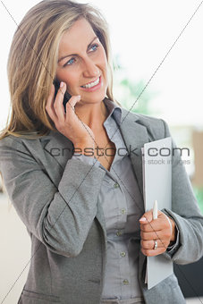 Smiling woman calling someone with her mobile phone