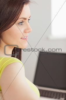 Concentrated girl using a laptop and looking away