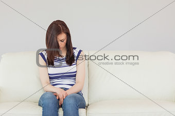 Depressed girl sitting on a sofa