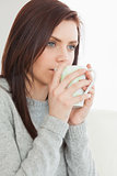Thinking girl drinking a cup of coffee