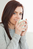 Smiling girl drinking a cup of coffee