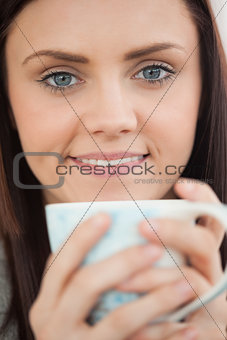 Smiling girl holding a cup of coffee