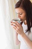 Thoughtful girl holding a cup of coffee eyes closed