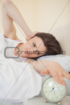 Upset girl turning off her alarm clock