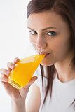 Smiling girl drinking a glass of orange juice