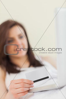 Smiling girl using her laptop to shop online