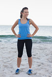 Brunette woman wearing sport wear in front of ocean