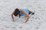 Woman doing push ups at beach