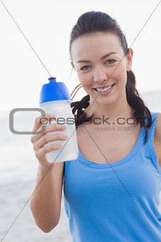 Smiling woman showing her water bottle