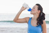 Brunette woman drinking after exercising