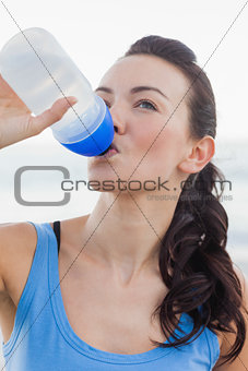 Close up view of woman drinking water after working out